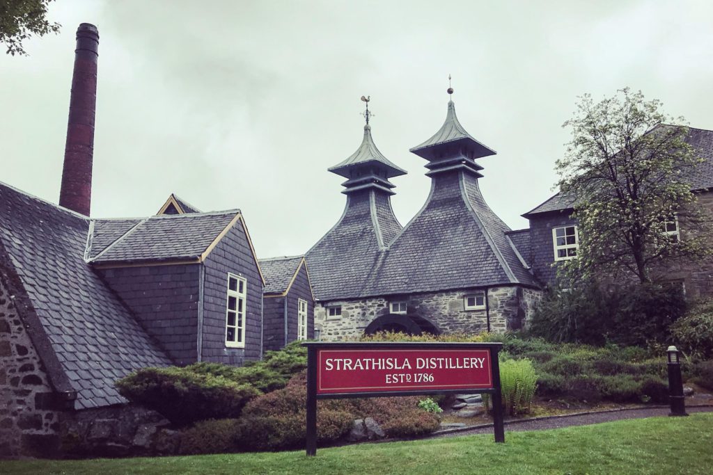 The sign for Strathisla Distillery outside of the stone distillery facility in the Scottish Highlands