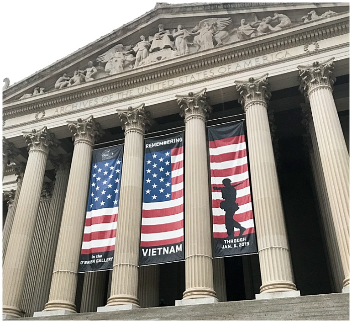 The main entrance to the National Archives Building in Washington, DC displaying a banner advertising a Veitnam War exhibit.