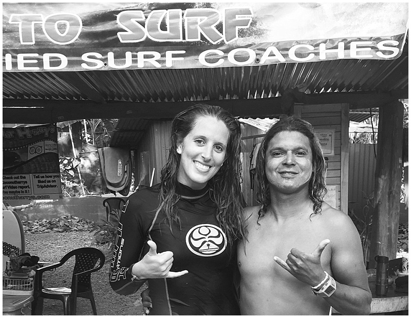 Male and Female surfer showing hang ten sign at Coconut Harry's Surf School in Nosara, Costa Rica