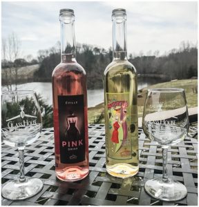 A bottle of Rose and White Wine with two wine glasses sitting on the patio table at Glass House Winery in Charlottesville, VA
